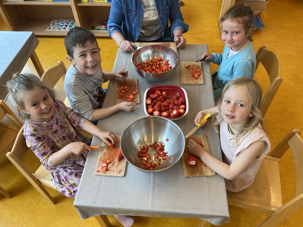 Kinder schneiden Erdbeeren