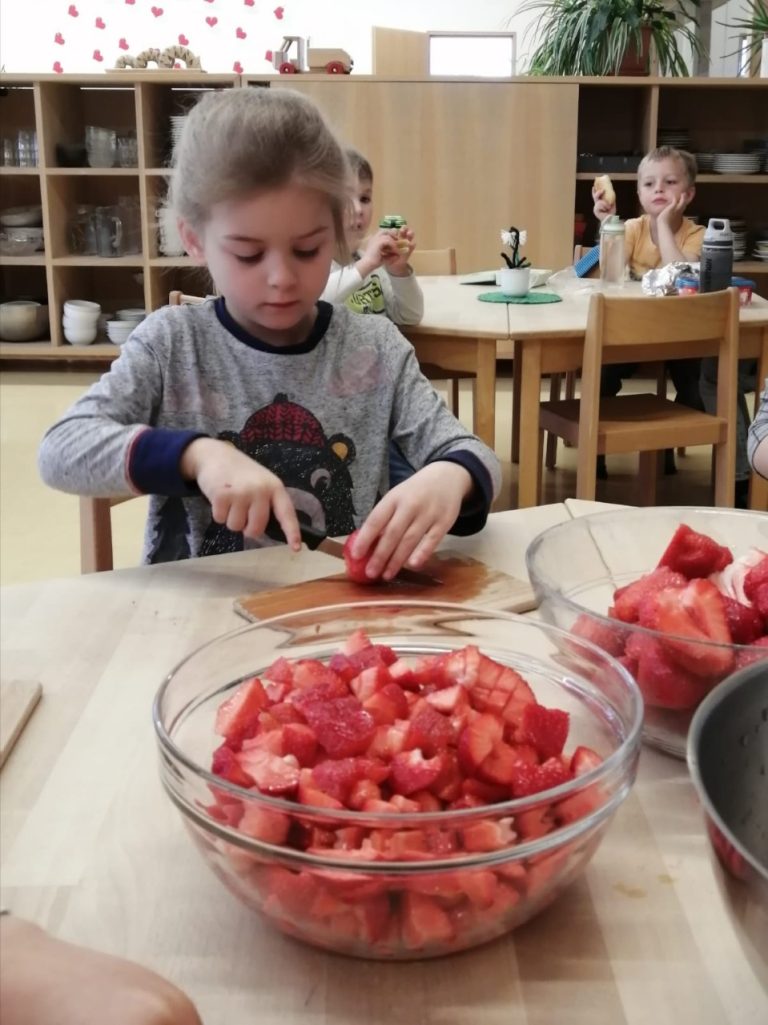 Kind schneidet Erdbeeren